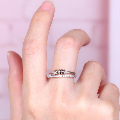 Anillo Axia: Anillo moderno con patillas paralelas y detalles cilíndricos de metal pulido.